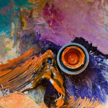 Colorful paint palette with an open orange paint bottle.