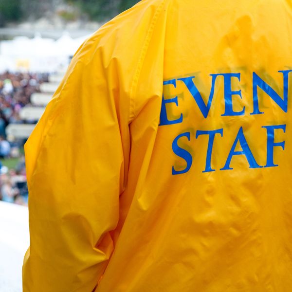 Person wearing a yellow event staff jacket.