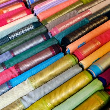 Colorful rolls of fabric arranged neatly.