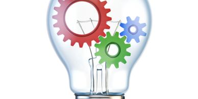 A light bulb with colorful gears inside symbolizing innovation and ideas.