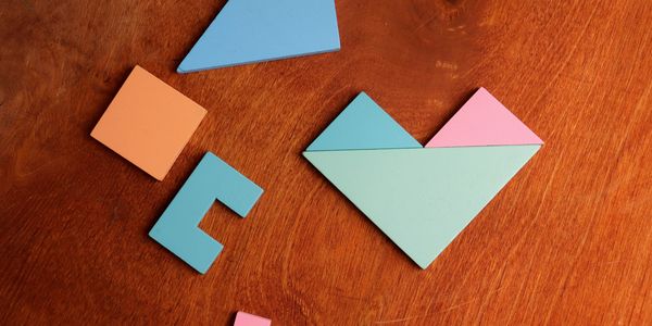 Colorful geometric wooden shapes on a wooden surface.