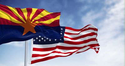 Arizona state flag alongside the United States flag waving in the wind.