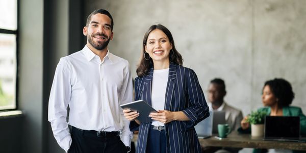 2 happy business people smiling in an office setting