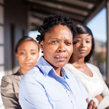 Three confident women standing together, focused and determined.