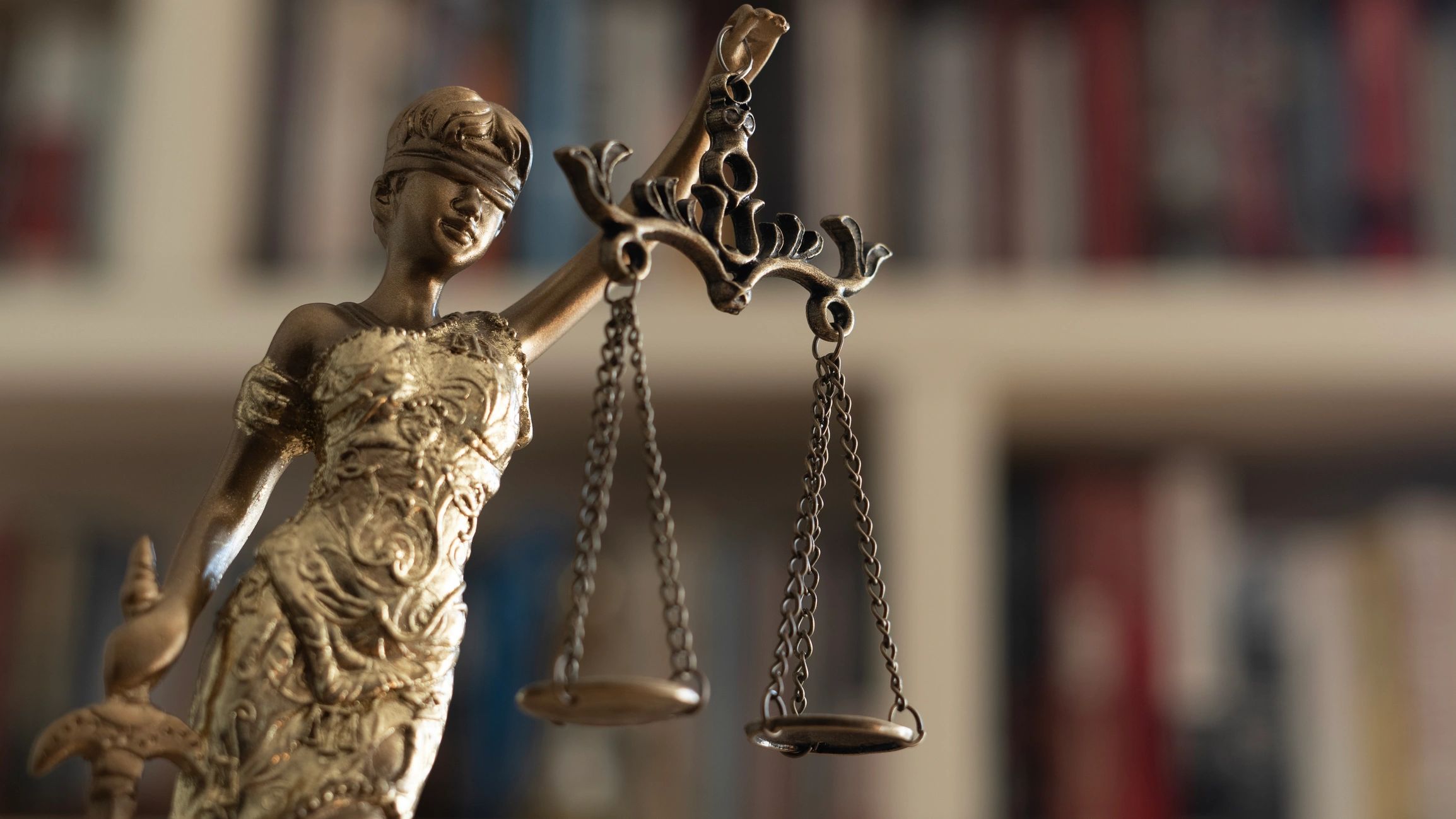 Lady Justice, blindfolded, holding a scale in her left hand and a sword in her right.