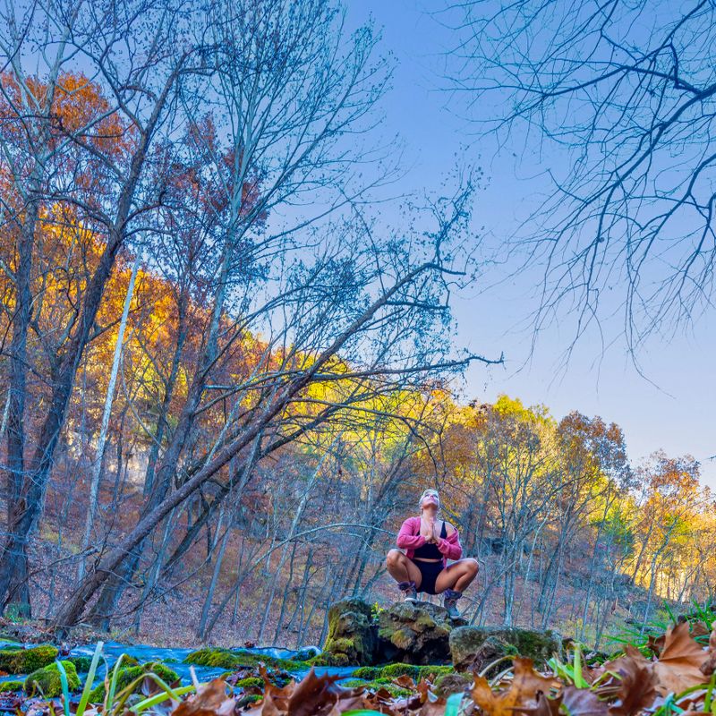 An authentic woman in nature practicing mindfulness through connection to nature in meditation. Shot at Ha Ha Tonka State Park in Lake Ozarks.