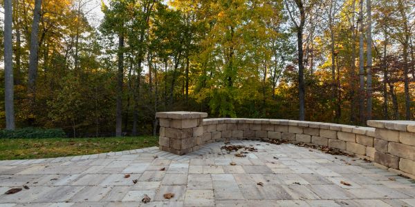 Empty stone patio with autumn trees in the background.