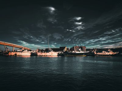 Boats docked under a dramatic sky at dusk.