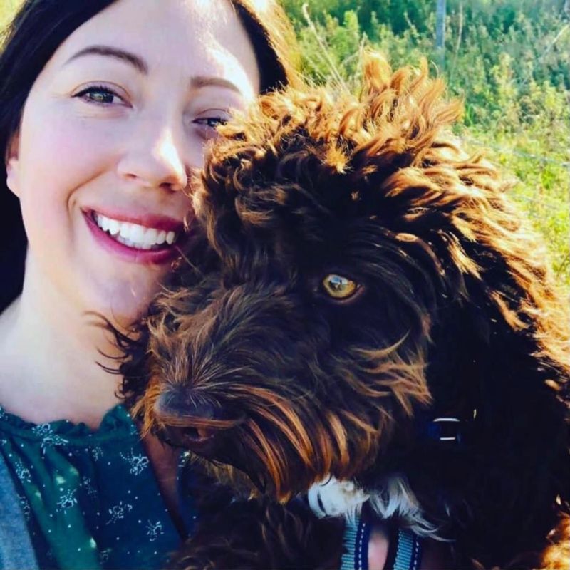 A smiling woman and her dog outdoors