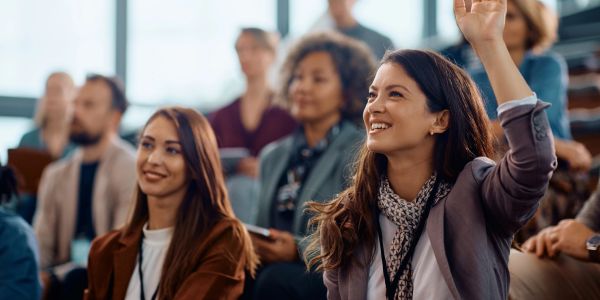 Woman raising hand in a conference or seminar.