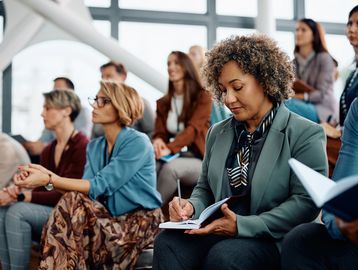 Woman taking notes during a seminar.