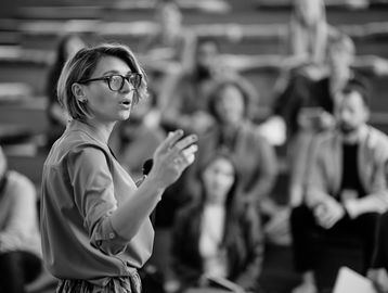 A woman giving a presentation to an audience.