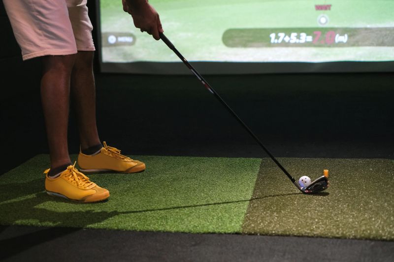 Close up shot of unrecognizable man ready to hit golf ball at virtual golf simulator