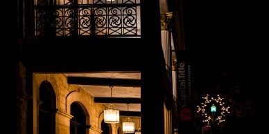 Historic building porch illuminated at night.