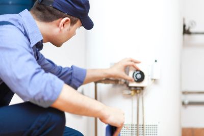 Technician adjusting settings on a boiler system.