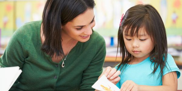 Woman teaching a child how to read