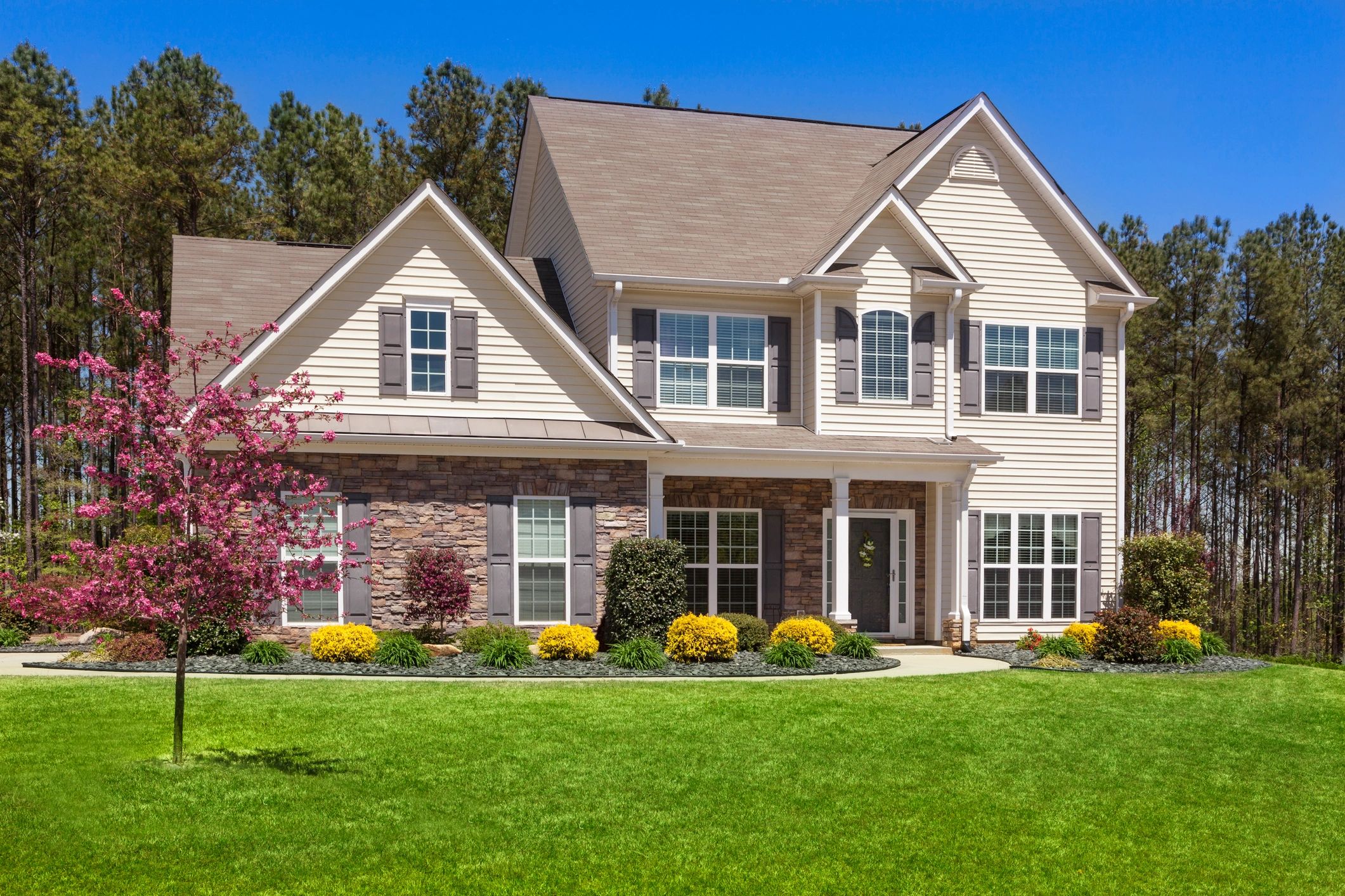 A beautiful suburban house with stone and siding exterior.