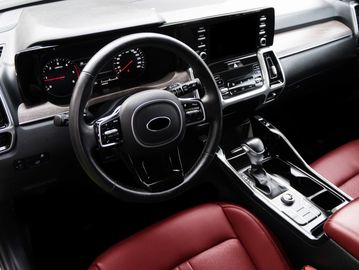 Modern car interior with black dashboard and red leather seats.