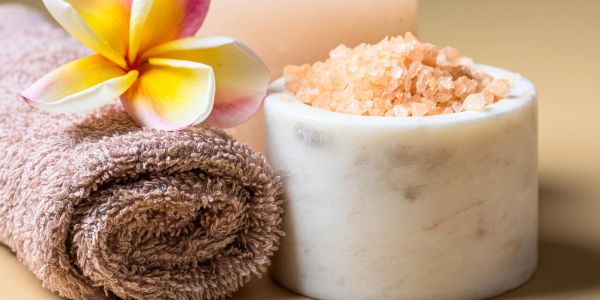 Towel, flower, and bath salts for relaxation.