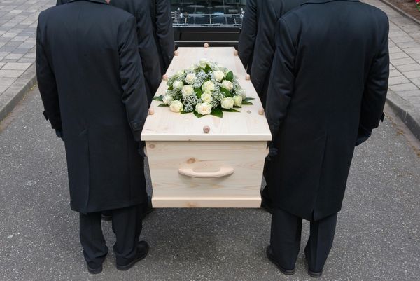 This image depicts a solemn scene, likely a funeral or a procession.