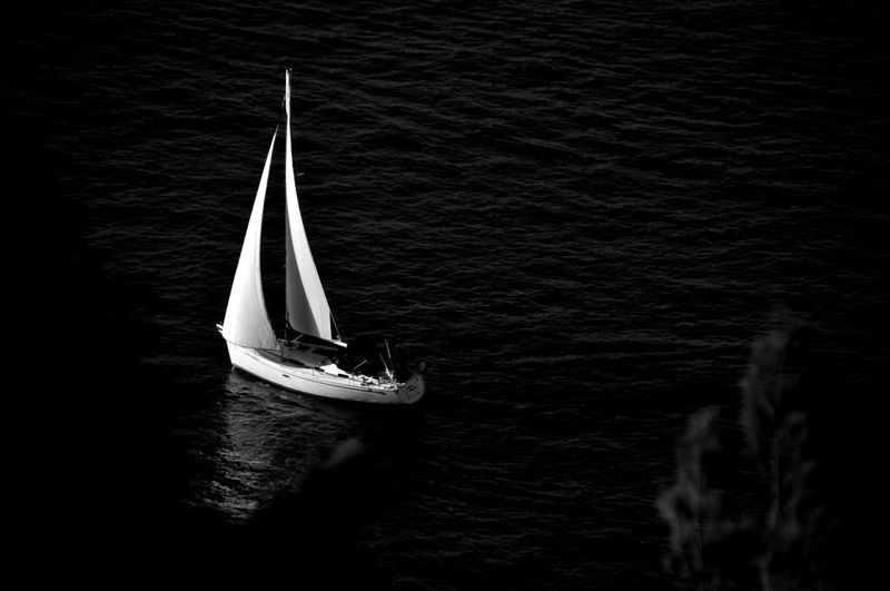 White sailing boat sailing in water.