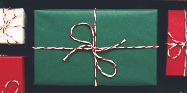 Christmas presents wrapped in red, green, and white with striped twine bows.