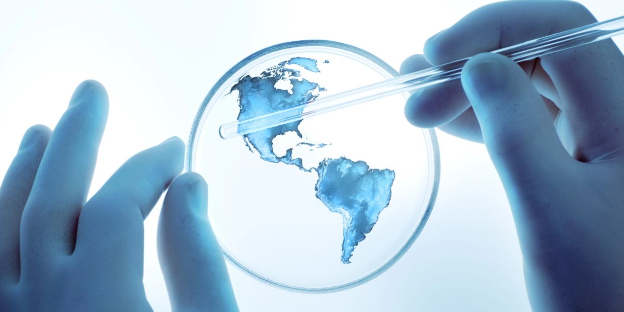 Petri dish with Americas map and lab hands.