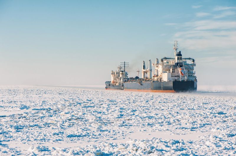 Winter shipping. Big cargo ships in frozen ice sea fairway