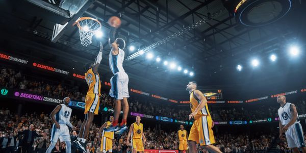 Basketball player dunking the ball during a game.