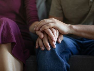 Couple holding hands, showing affection.