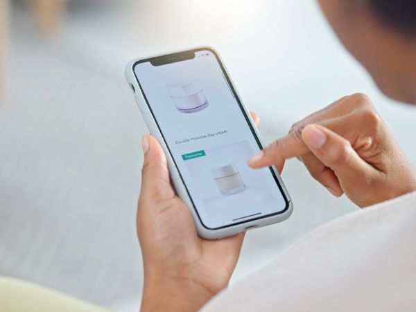 Person shopping for skincare products on a smartphone.
