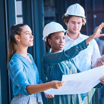 Three people looking at blueprints.  