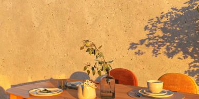 Cozy outdoor dining setup with warm orange chairs and rustic decor.