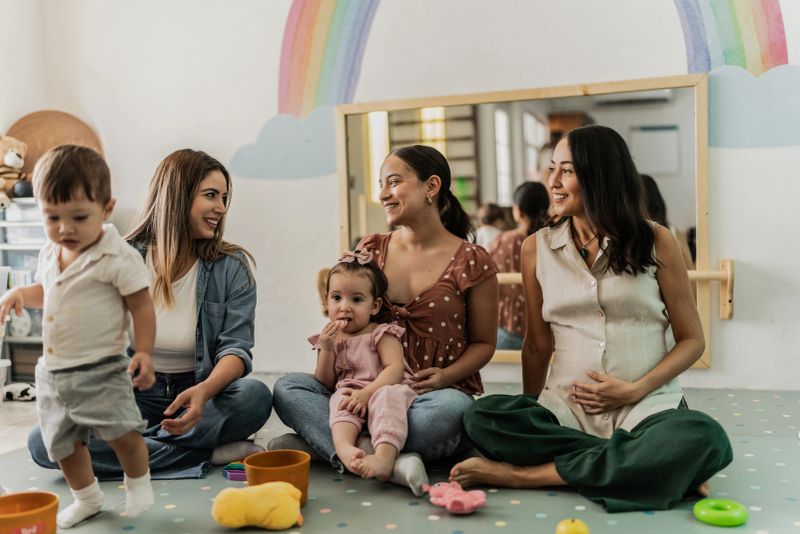 Mothers talking while their babies playing in the playroom