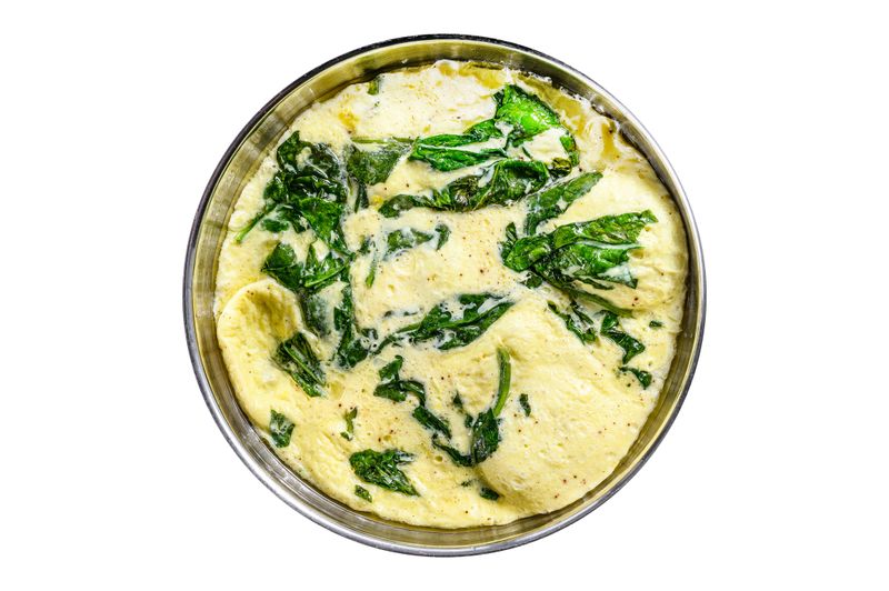 Italian Spinach and Cheese Omelet in a pan.   Isolate, white background