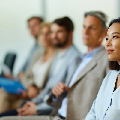 A group of professionals attentively listening in a meeting or seminar.