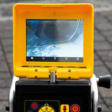 A yellow electronic device with a screen showing an underwater or pipe view.