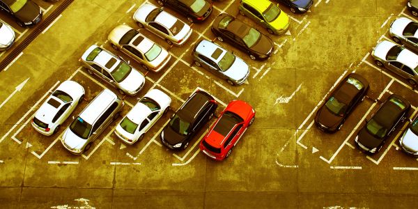 Aerial view of a crowded parking lot with cars parked in marked spaces.