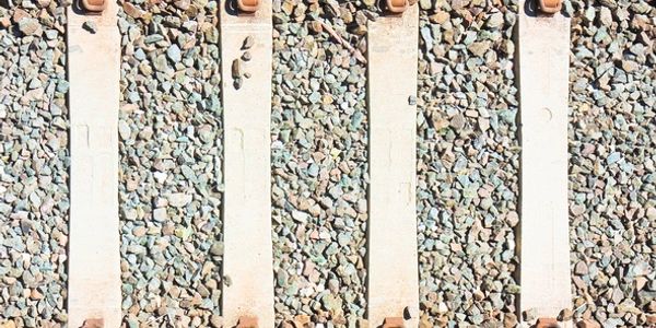 Close-up of gravel and concrete railroad ties.