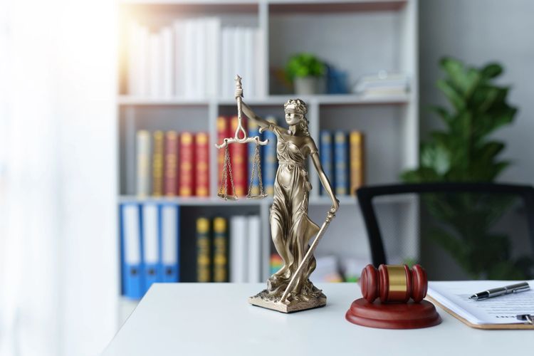 Stack of books next to pencils in a holder and a camera.
