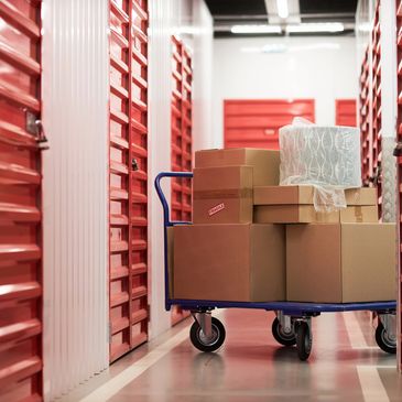 Cart with cardboard boxes in a storage facility hallway.