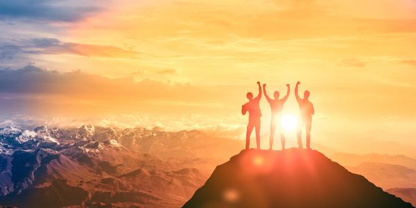 A group of people standing at the top of a mountain