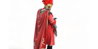 Person in a red Roman soldier costume looking at a phone.