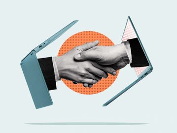 Two hands shaking through laptop screens symbolizing virtual agreement.