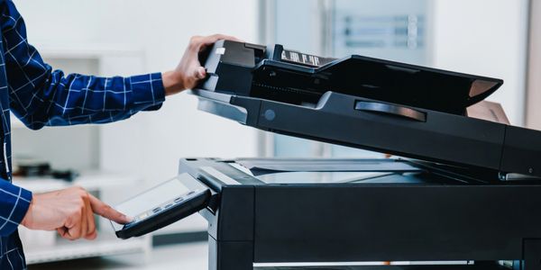 Male office employee configuring the business printers and photo copiers for IT services