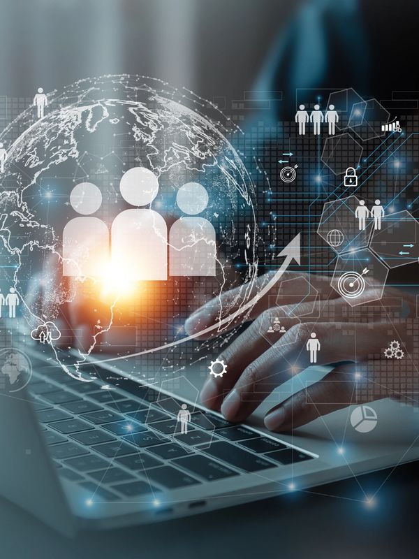 Hands typing on a laptop with digital social network and data icons overlay.