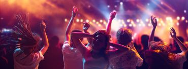 Three friends posing together in a dimly lit bar or club.