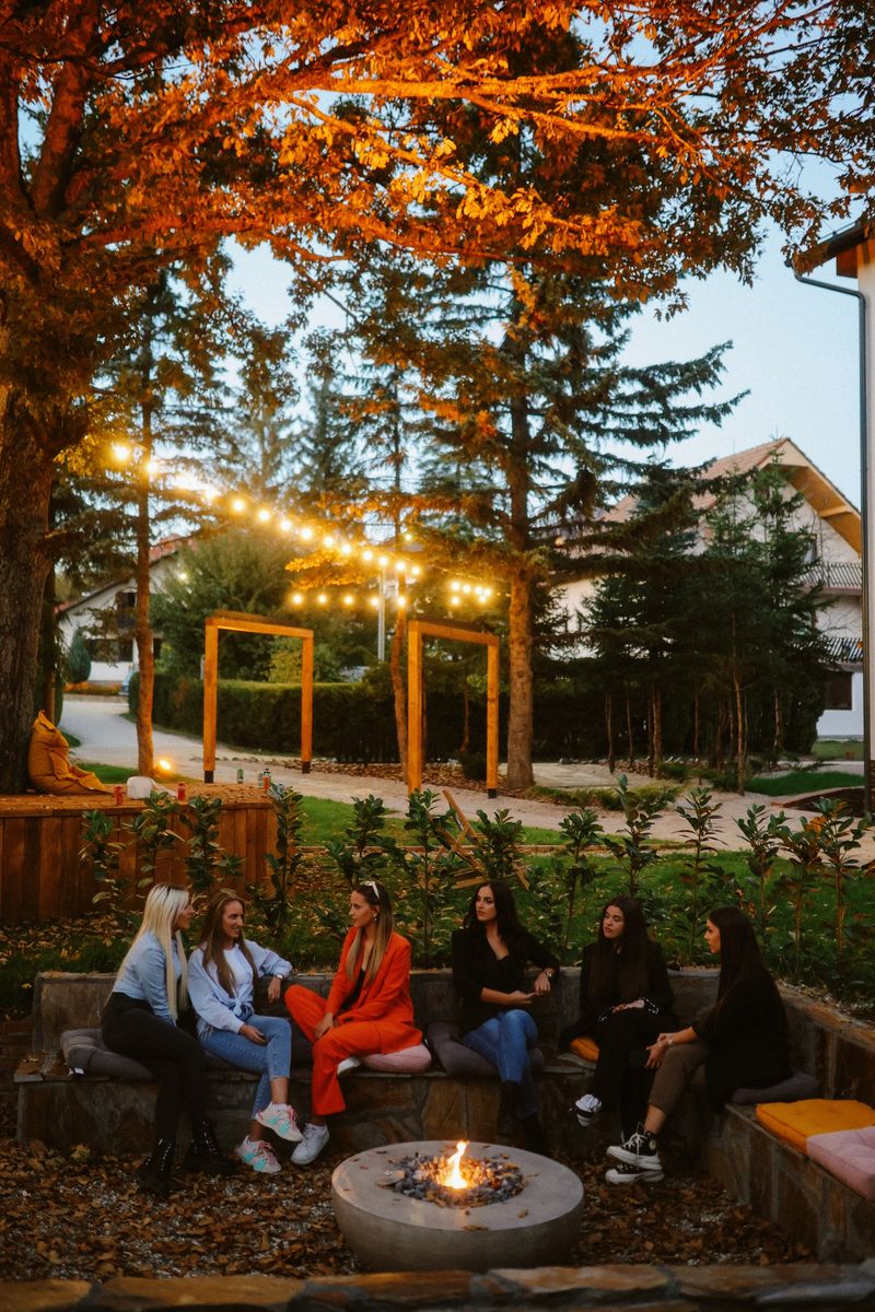 Coworkers having a team building weekend. Chatting in a hotel yard, discussing work, spending an easy afternoon in a pet friendly environment.
