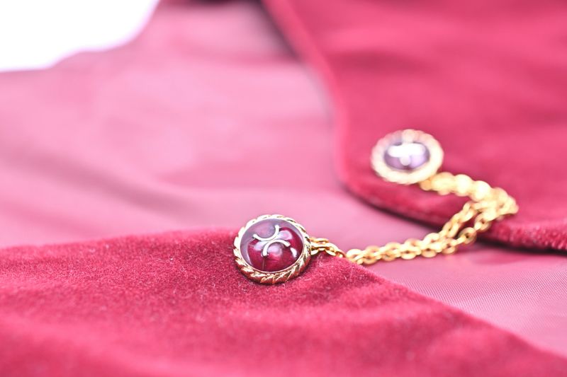 A golden chain adorning a bright red women's suede vest