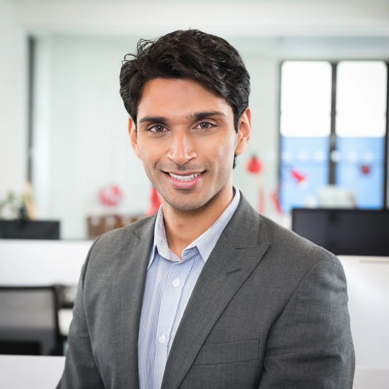Portrait of confident young businessman smiling in office.